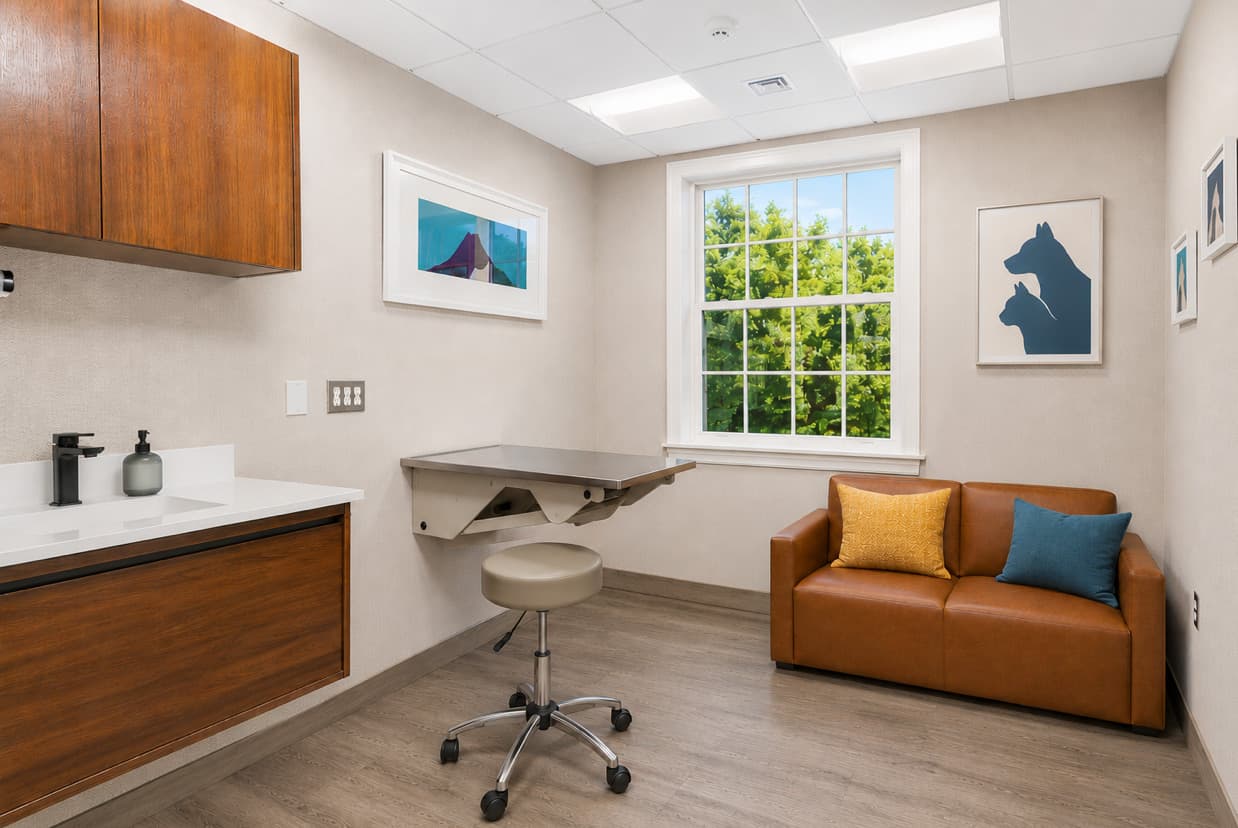 Exam room with built-in cabinetry, exam table, and seating